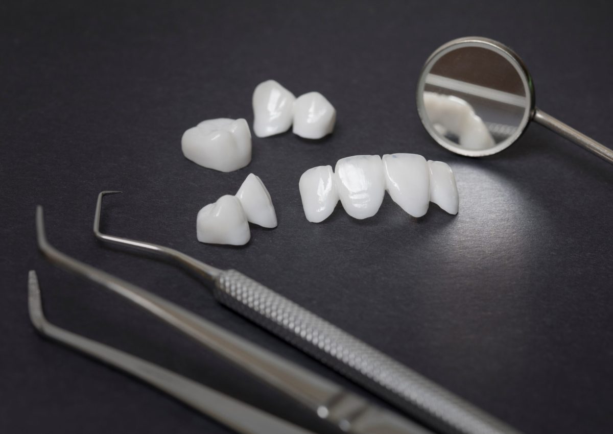 Dental tools and zircon dentures on a dark background - Ceramic veneers - lumineers
