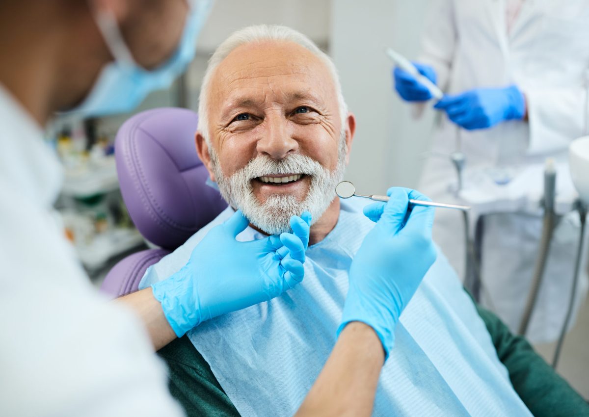 Happy senior man having dental treatment at dentist's office.